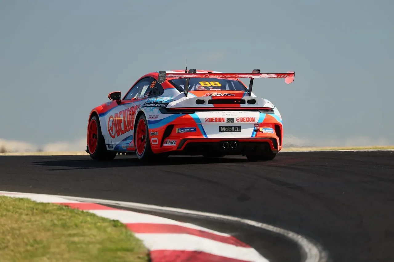 Rear view of the number 88 Dexion Porsche 911 GT3 Cup car on track beside a red and white kerb