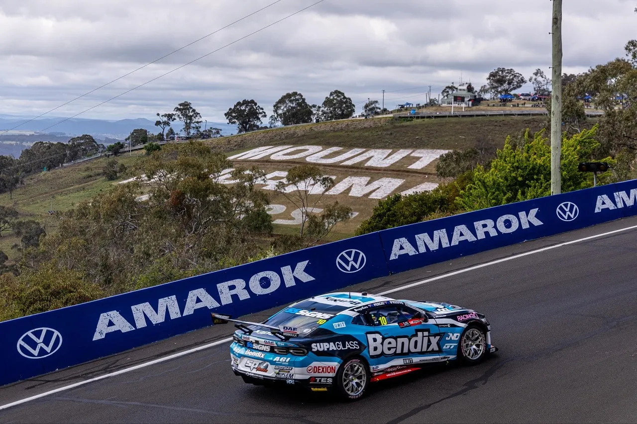 A race car cresting Mount Panorama at Bathurst beneath the Mount Panorama sign