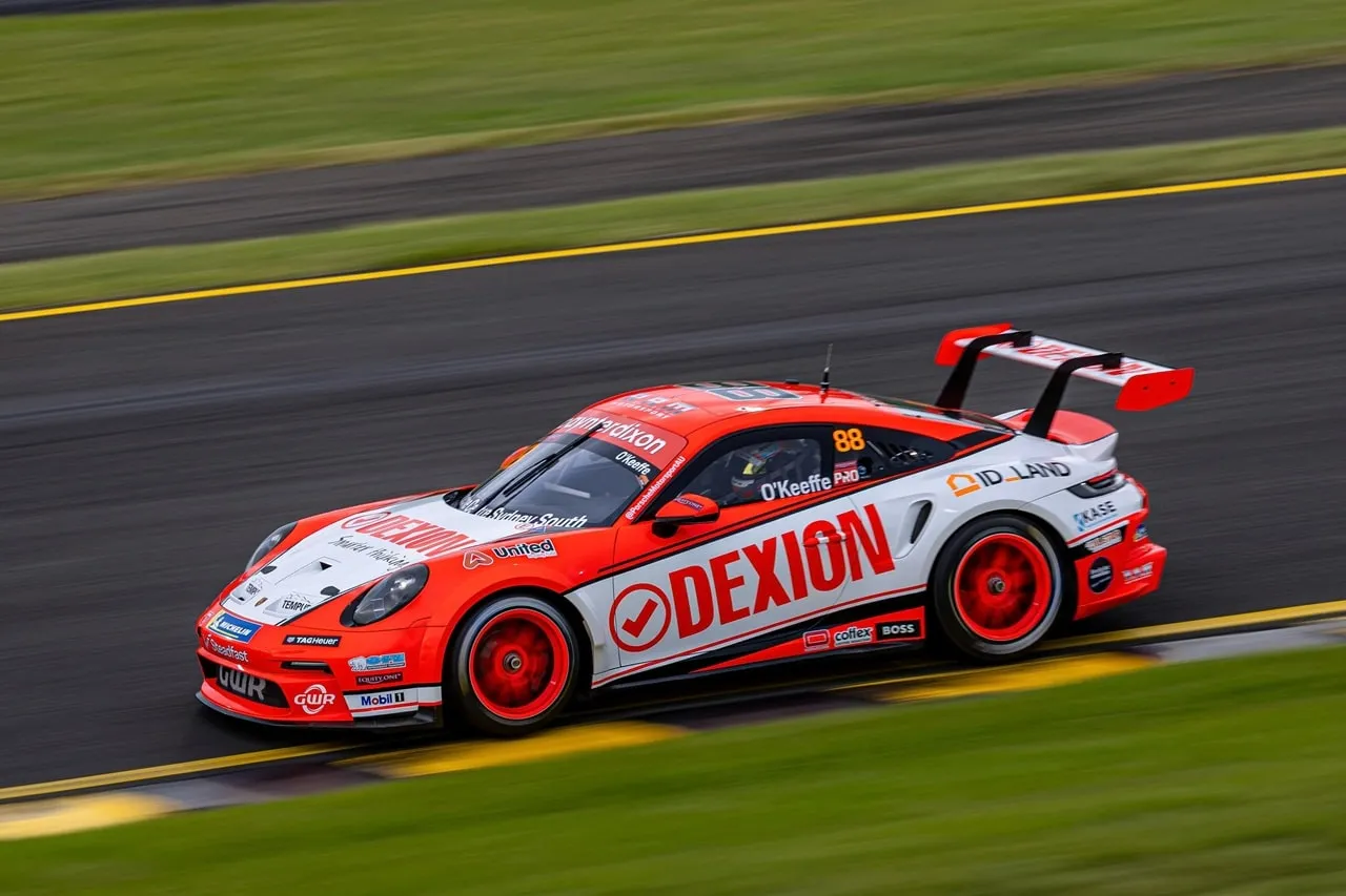 Side view of the Dexion Porsche #88 with O’Keeffe on the window, on track