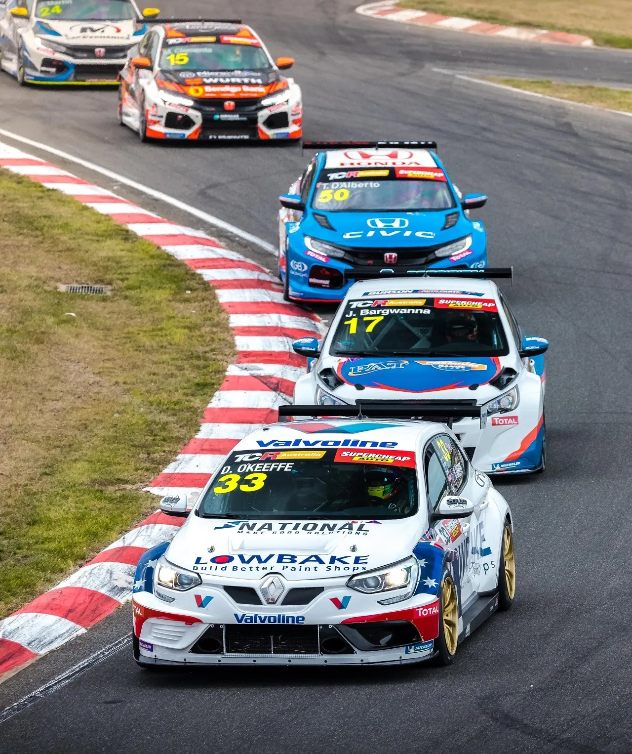 The #33 Renault Megane TCR car leading a queue of TCR cars, including a blue Honda Civic, through a corner