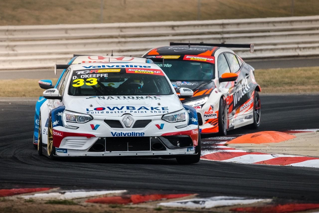 The white #33 Lowbake Renault Megane TCR car racing just ahead of an orange and black TCR car