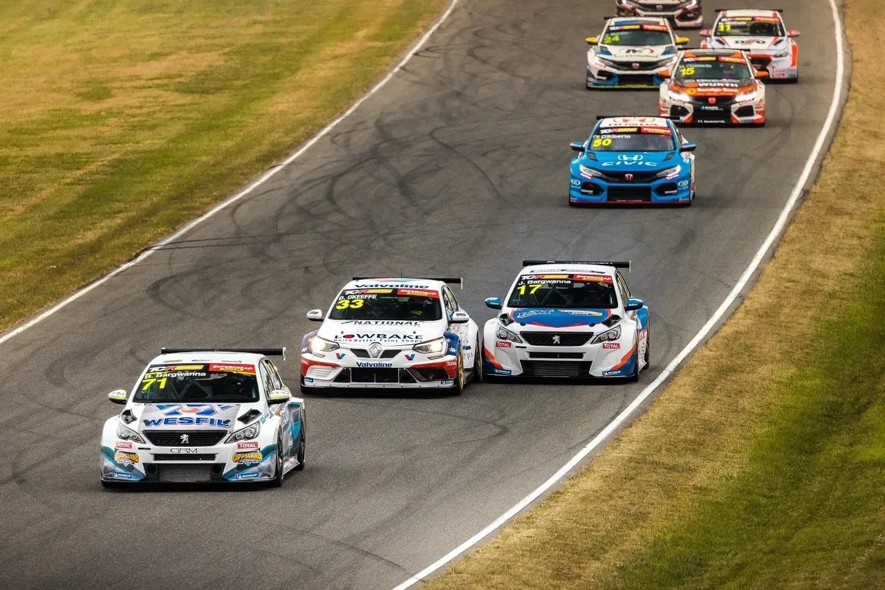 A pack of TCR touring cars racing up a straight, with the #33 Renault behind a Peugeot and ahead of a Peugeot #17