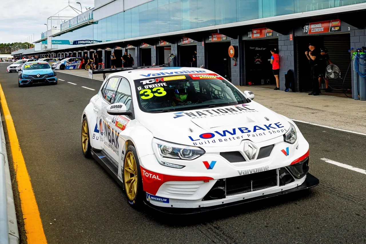 The white #33 Renault Megane TCR car with Lowbake livery driving down pit lane past the garages