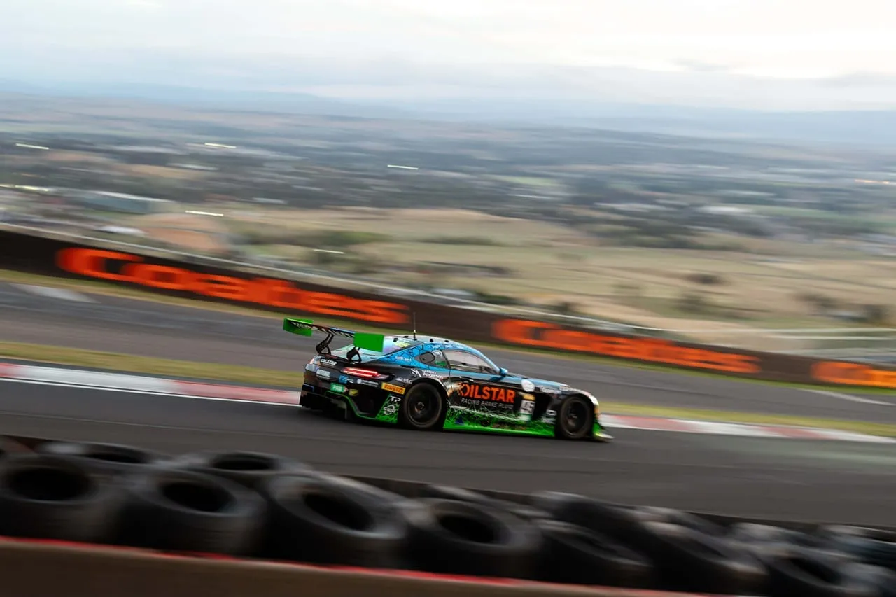 A GT car at speed across the top of Mount Panorama, the plains stretching out below