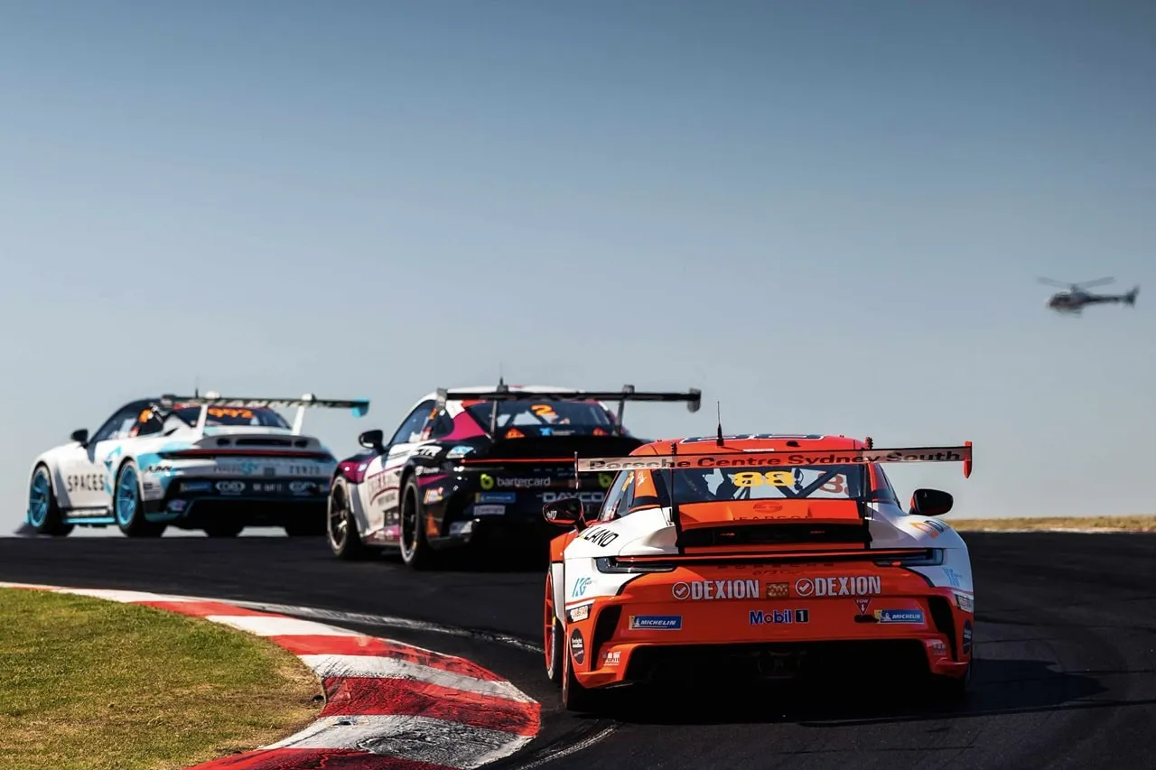 Rear view of the Dexion Porsche #88 chasing two Carrera Cup cars with a helicopter overhead