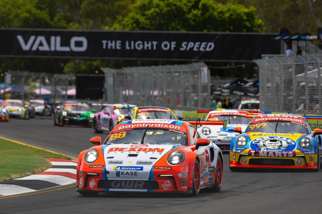 Dexion number 88 Porsche Carrera Cup car leads a pack of cars past a VAILO banner on a street circuit