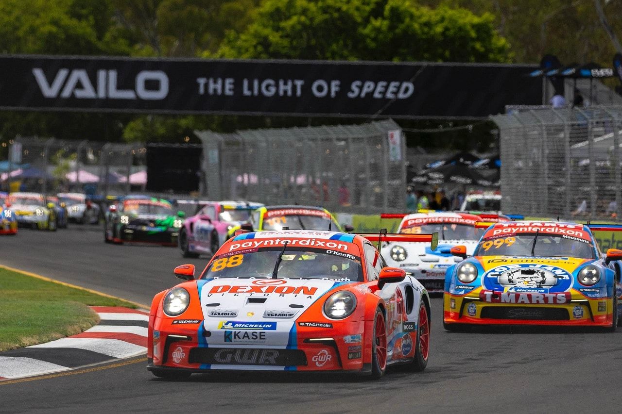 Dexion number 88 Porsche Carrera Cup car leads a pack of cars past a VAILO banner on a street circuit