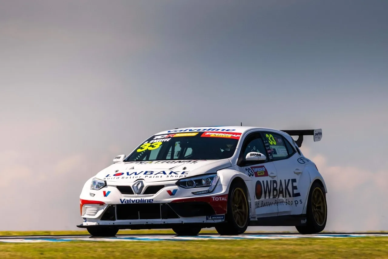 The white #33 Lowbake Renault Megane TCR car on a dry track under a grey, cloudy sky