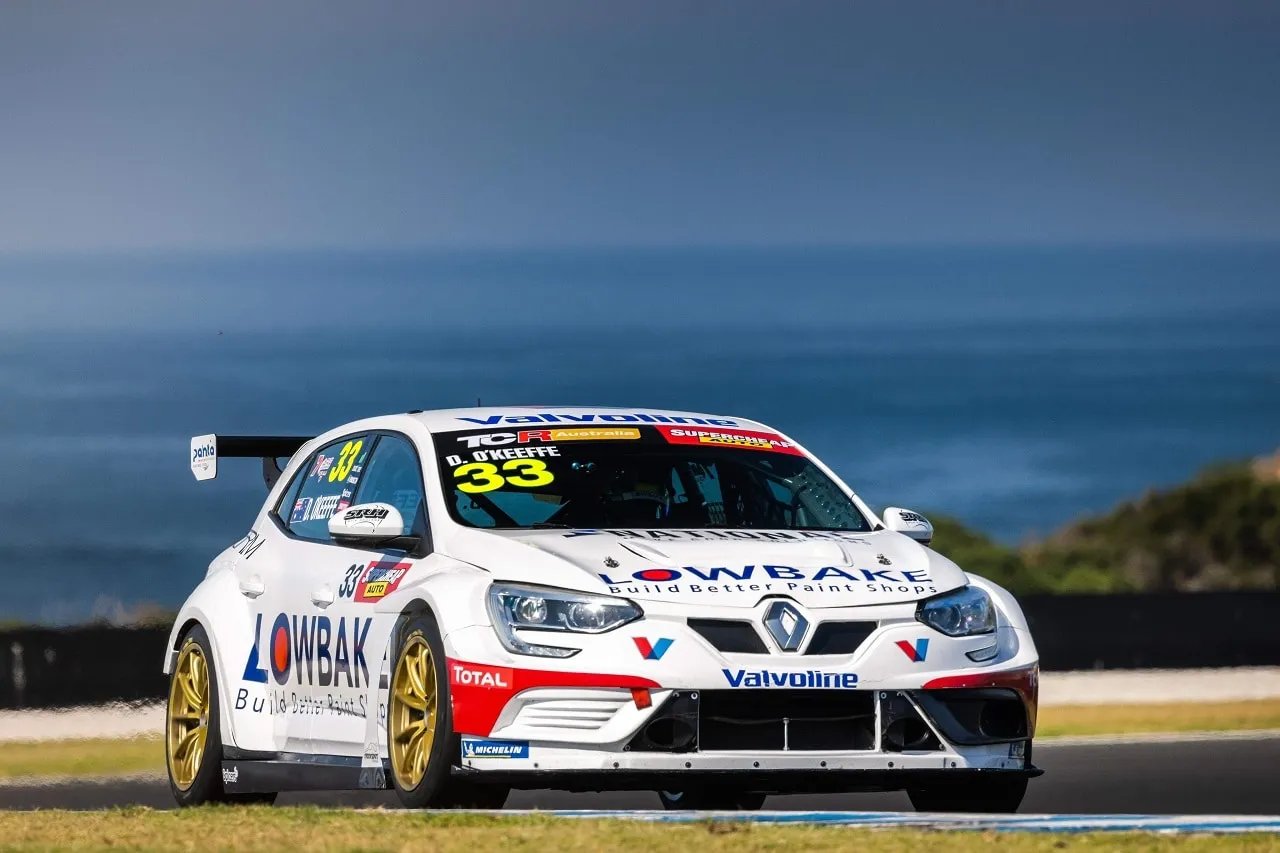 The white #33 Lowbake Renault Megane TCR car on track with the ocean in the background