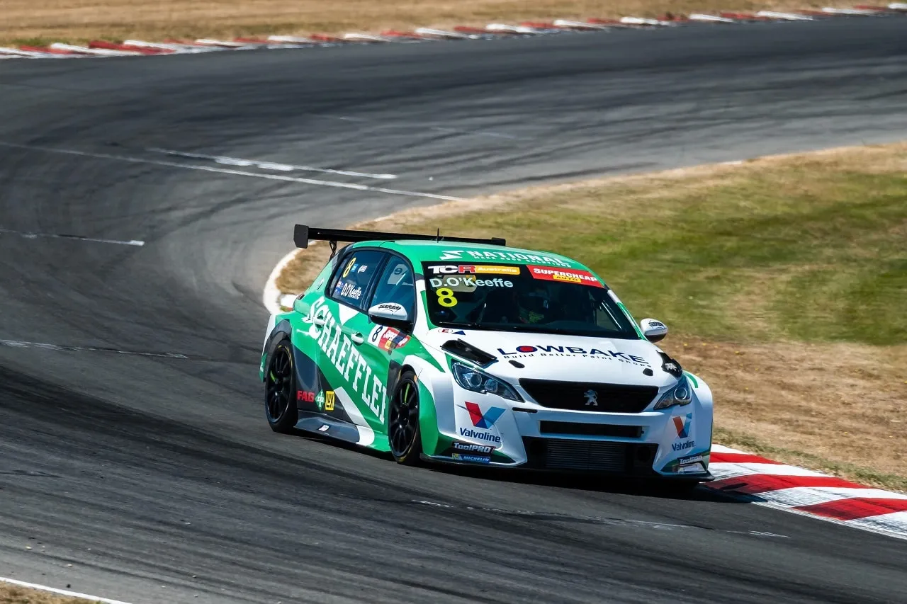 The #8 Schaeffler Peugeot 308 TCR car powering through a corner past red and white kerbing