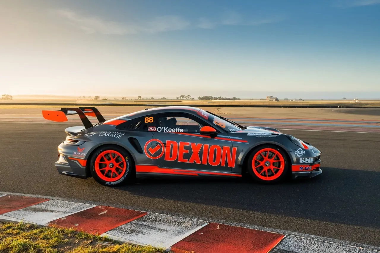 Side view of the number 88 Dexion Porsche 911 GT3 Cup car on track at sunset