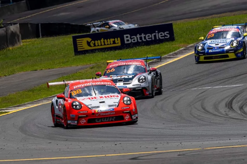 Dexion Porsche #88 leading two other Carrera Cup cars past a Century Batteries sign