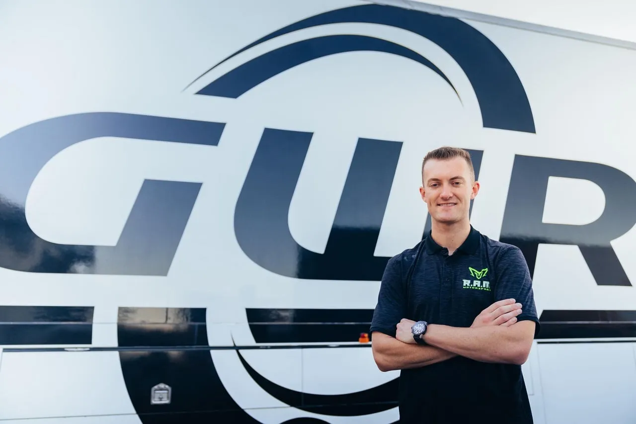 Dylan O’Keeffe smiling with arms folded in front of a large GWR team transporter
