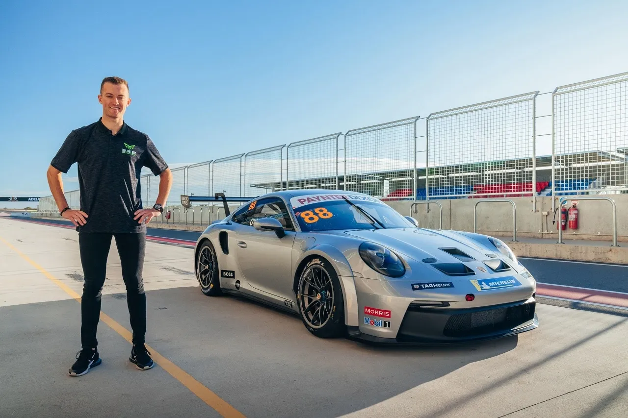 Dylan O’Keeffe standing in pit lane beside a silver #88 Porsche 911 GT3 Cup car