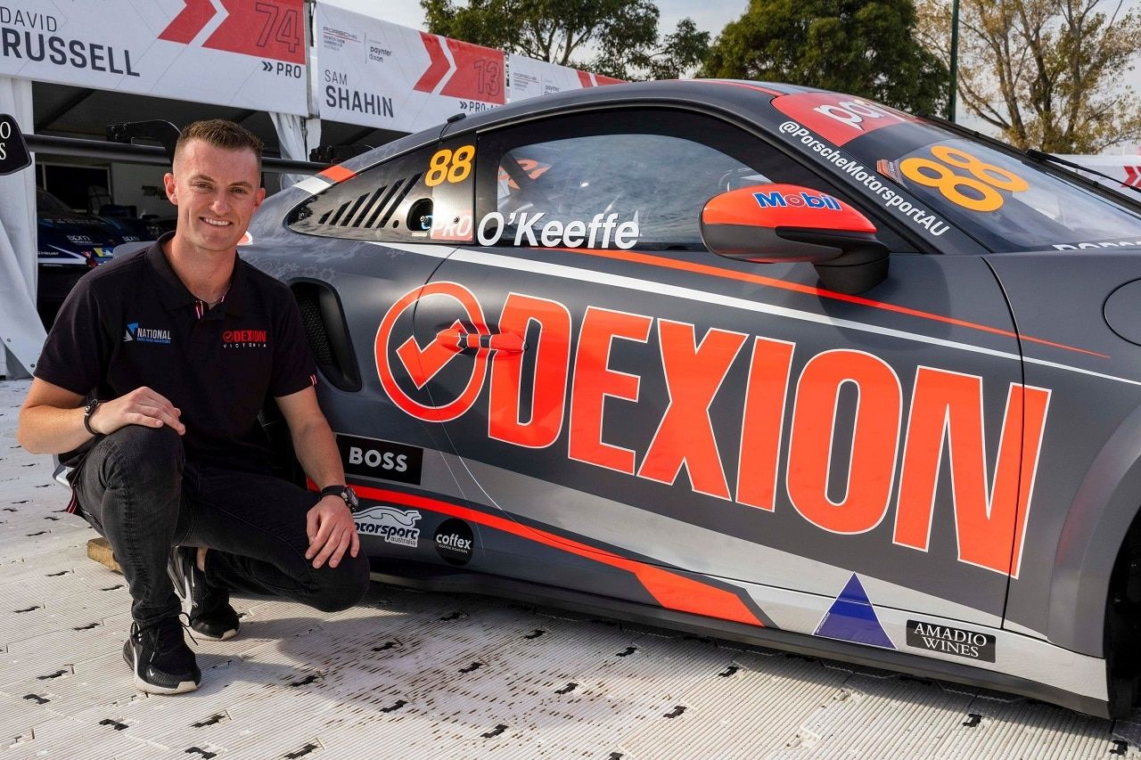 Dylan O’Keeffe crouching beside the Dexion livery on his #88 Porsche GT3 Cup car