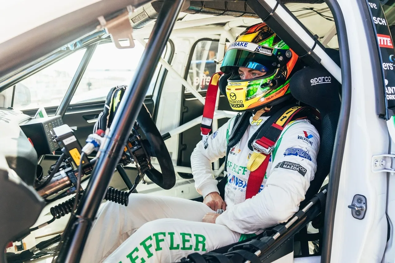 Dylan O’Keeffe in his Lowbake helmet and white Schaeffler race suit sitting in a TCR car