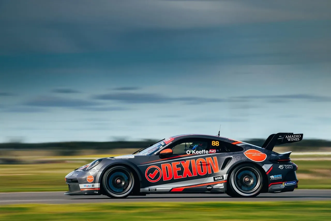 The #88 Dexion Porsche GT3 Cup car in side profile at speed with a blurred sky behind