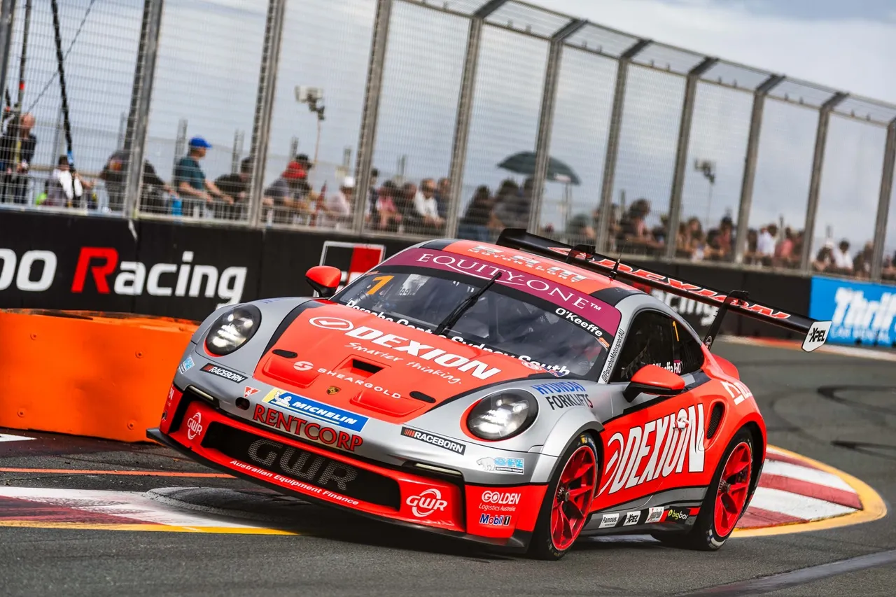 Dylan O’Keeffe’s #1 Dexion Porsche riding the kerb on the Gold Coast street circuit, fans watching through the catch fence