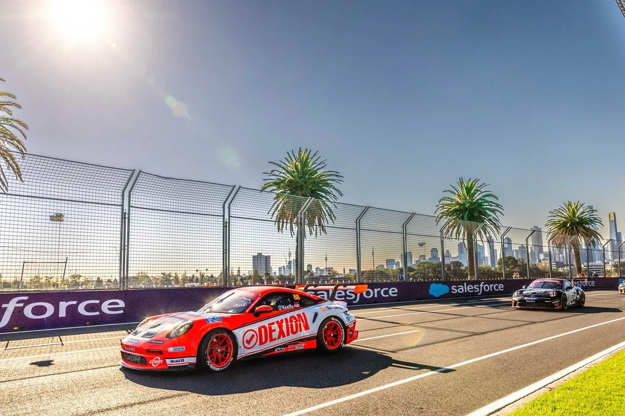Dexion Porsche racing in low sun past palm trees and Salesforce signage
