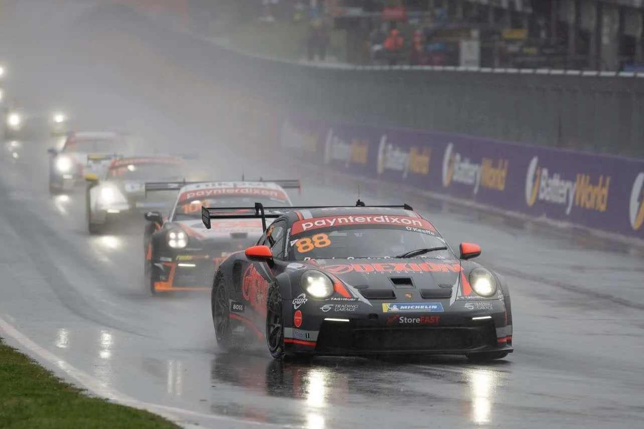 The #88 Dexion Porsche GT3 Cup car leads other cars through heavy rain and spray