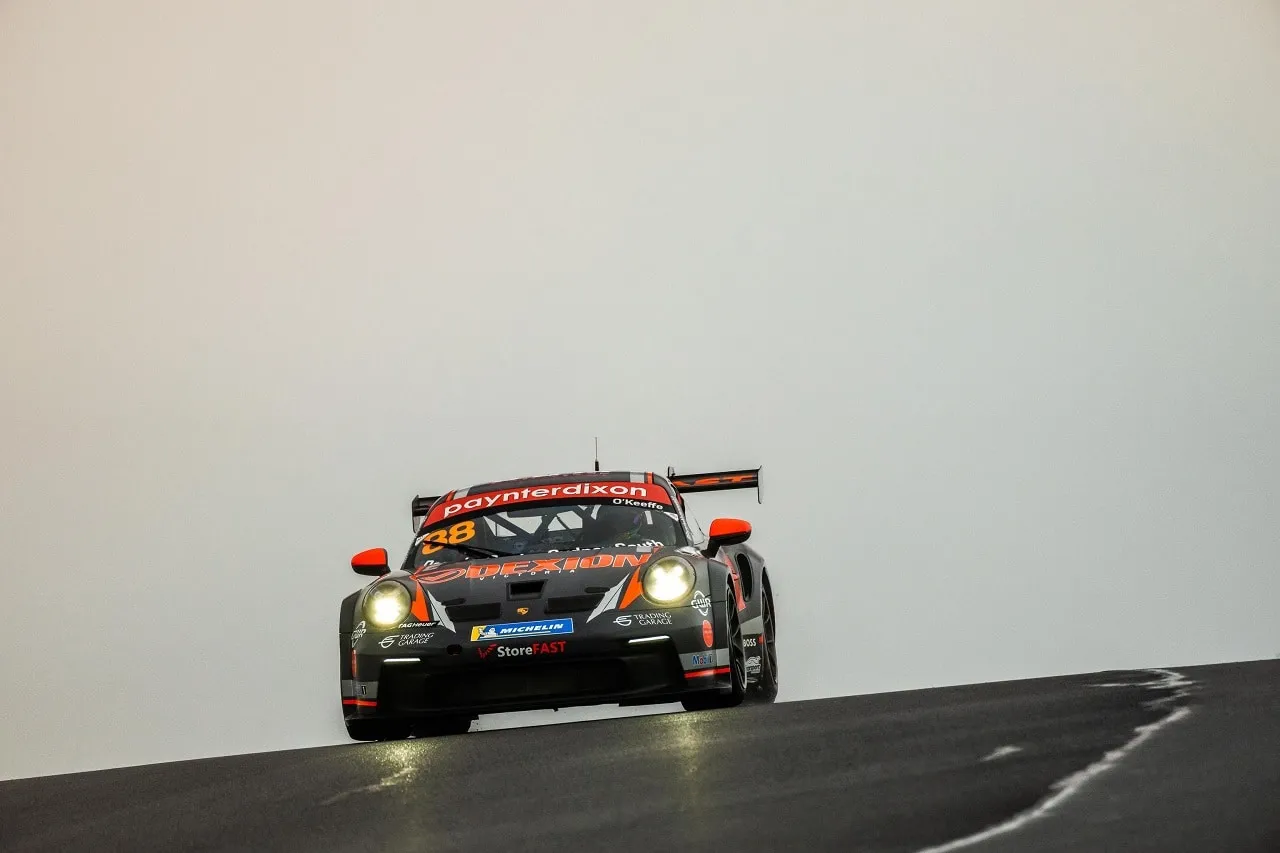 The number 88 Dexion Porsche 911 GT3 Cup car with headlights on in a misty, foggy sky on a rise