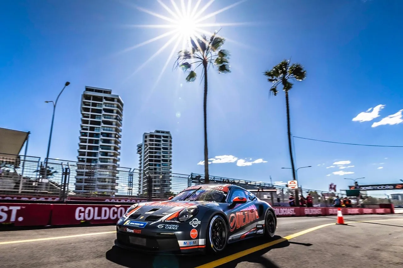 The Dexion Porsche 911 GT3 Cup car in the sun on the Gold Coast street circuit, with palm trees and towers behind