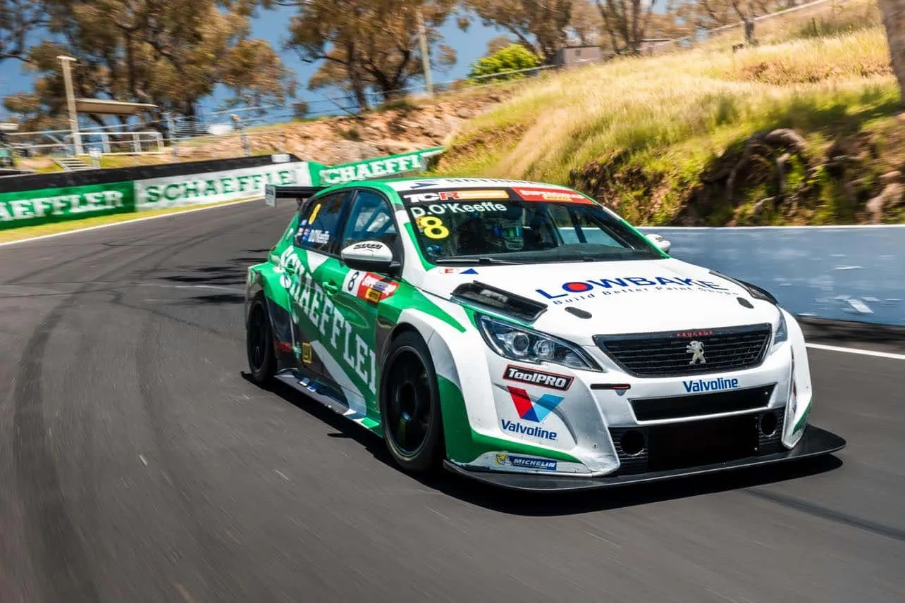 The green and white Schaeffler Peugeot 308 TCR car, number 8, driving up the hill at Bathurst