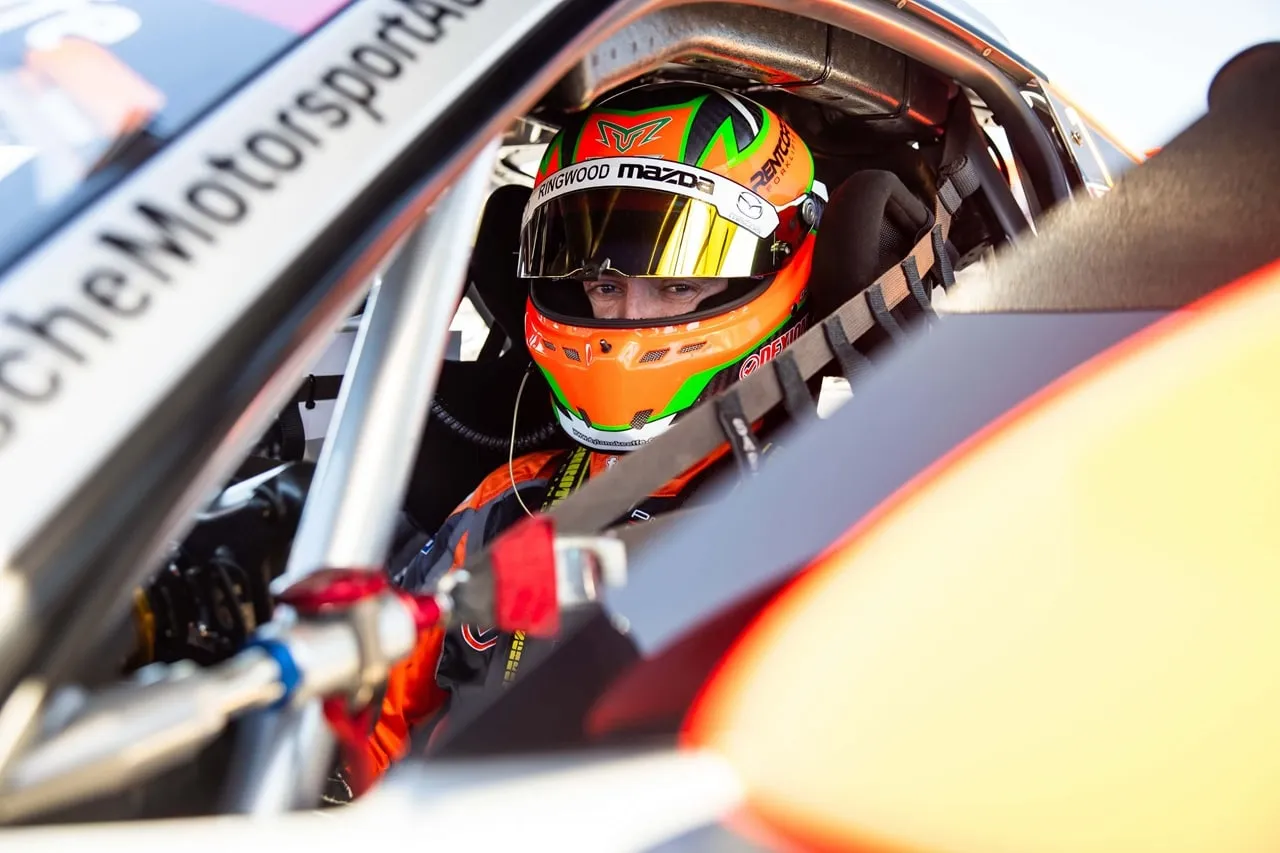 Dylan O’Keeffe in the cockpit of his Porsche, helmet on and visor up