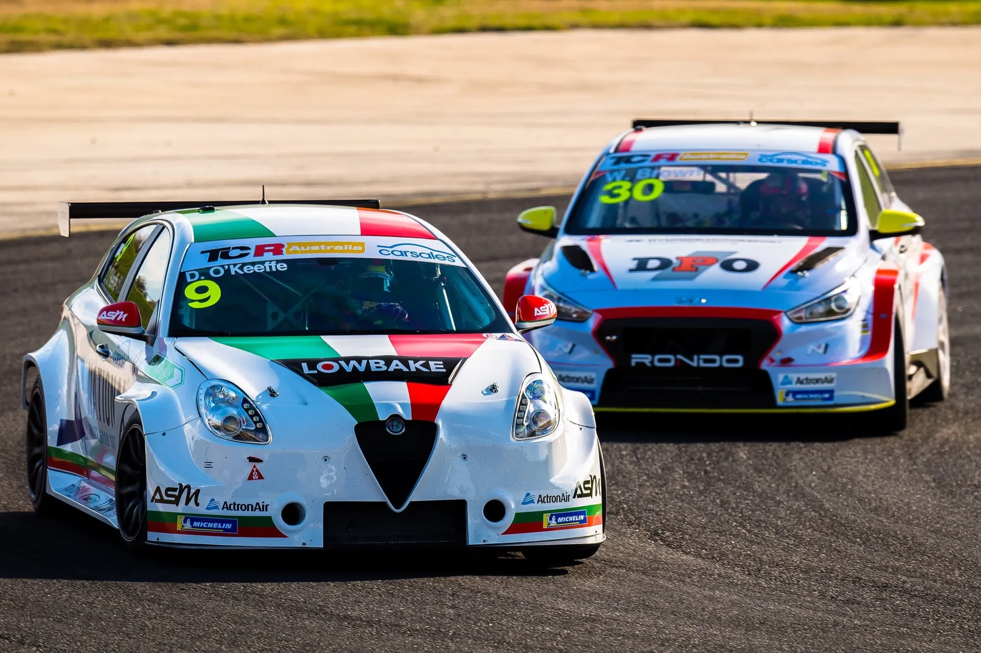 The white #9 Lowbake Alfa Romeo Giulietta TCR car of D. O’Keeffe racing alongside a #30 Hyundai TCR car