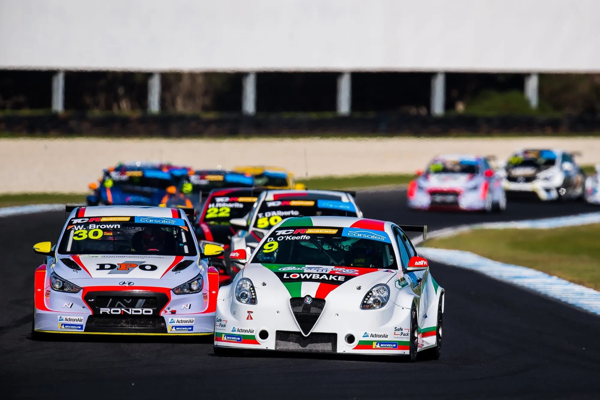 Dylan O’Keeffe’s #9 Lowbake Alfa Romeo TCR car in a tight pack of TCR cars including a #30 Hyundai