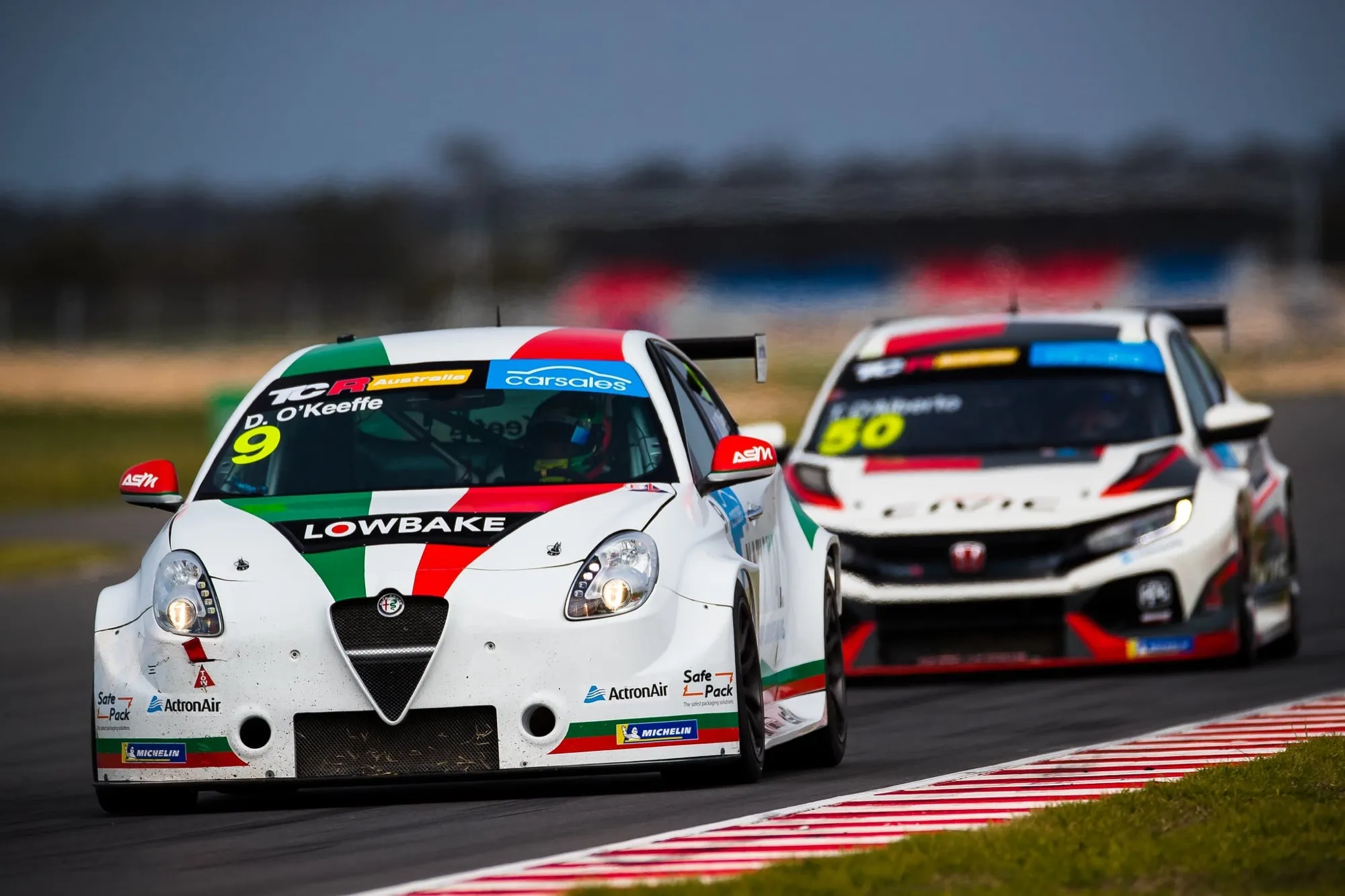 The white #9 Lowbake Alfa Romeo Giulietta TCR car of D. O’Keeffe racing ahead of a white Honda Civic TCR car