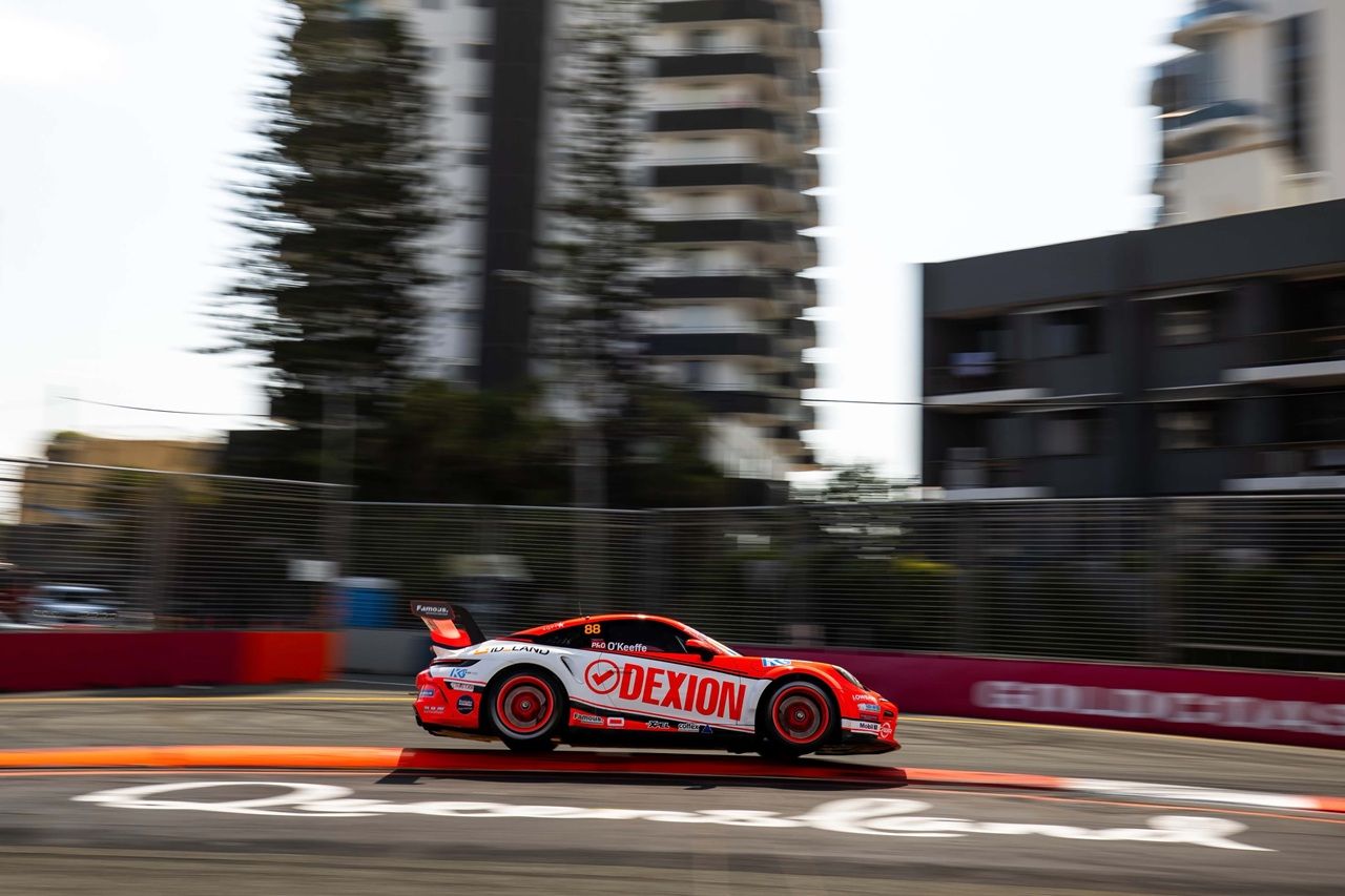 Dylan O’Keeffe’s Dexion Porsche at speed on the Gold Coast street circuit, high-rises blurred behind