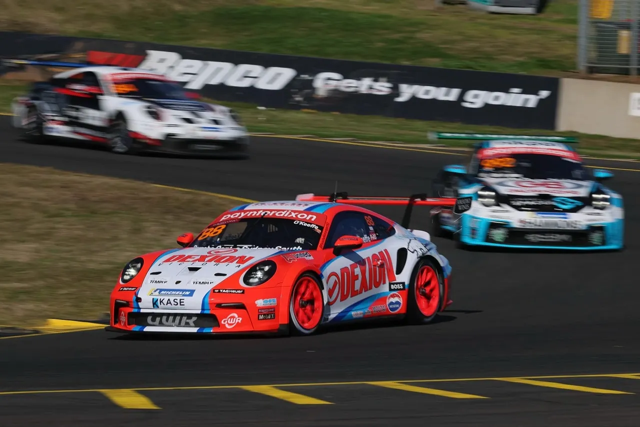 Number 88 Dexion Porsche Carrera Cup car on track with two rival Porsches behind