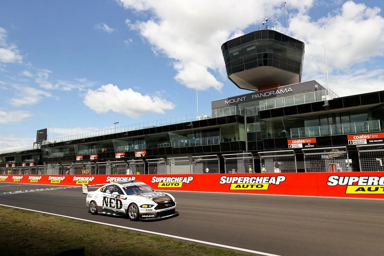 The NED Whisky Ford Mustang Supercar on track in front of the Mount Panorama pit complex and control tower