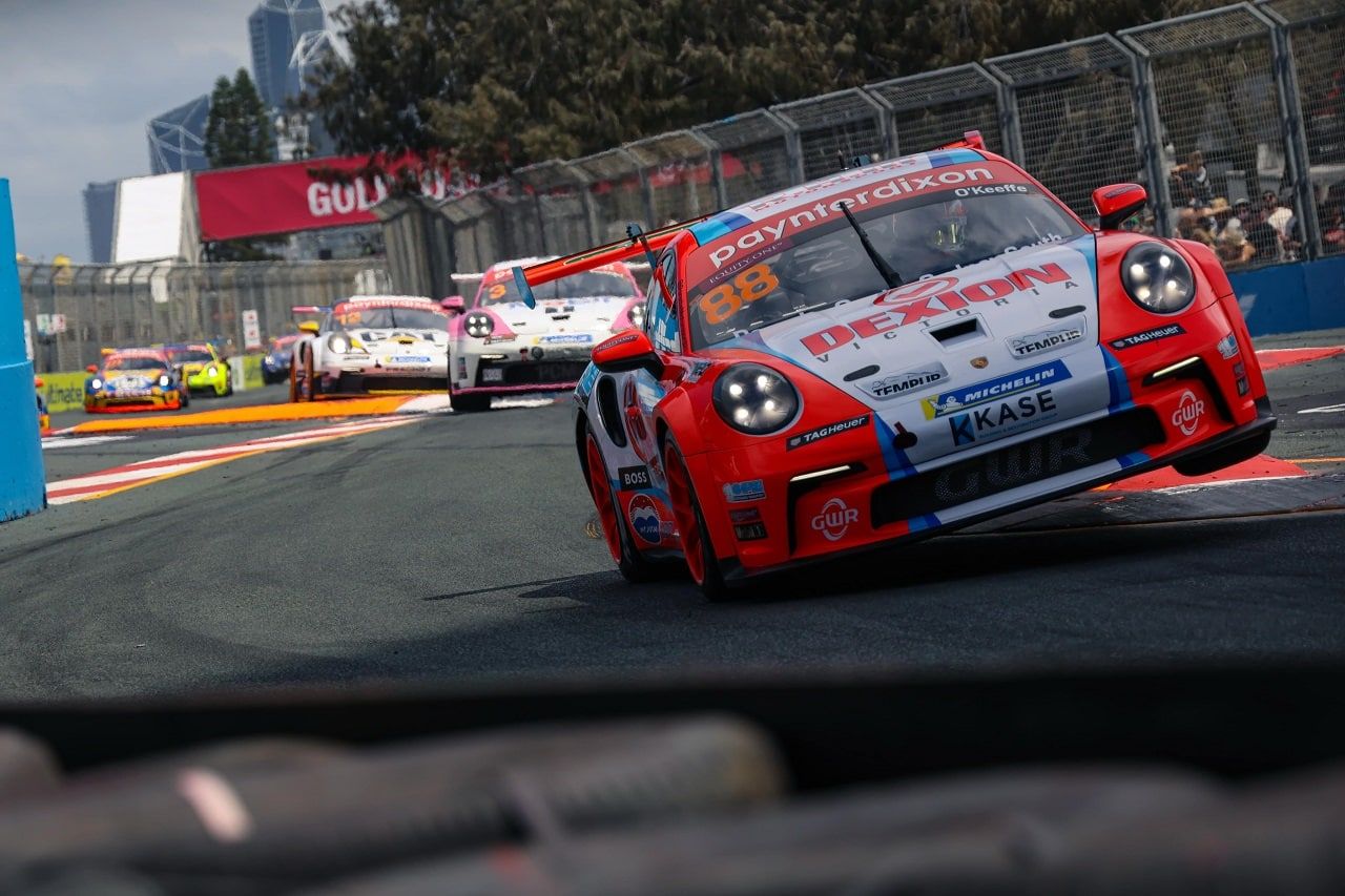 Number 88 Dexion Porsche Carrera Cup car cornering on a street circuit with other cars close behind