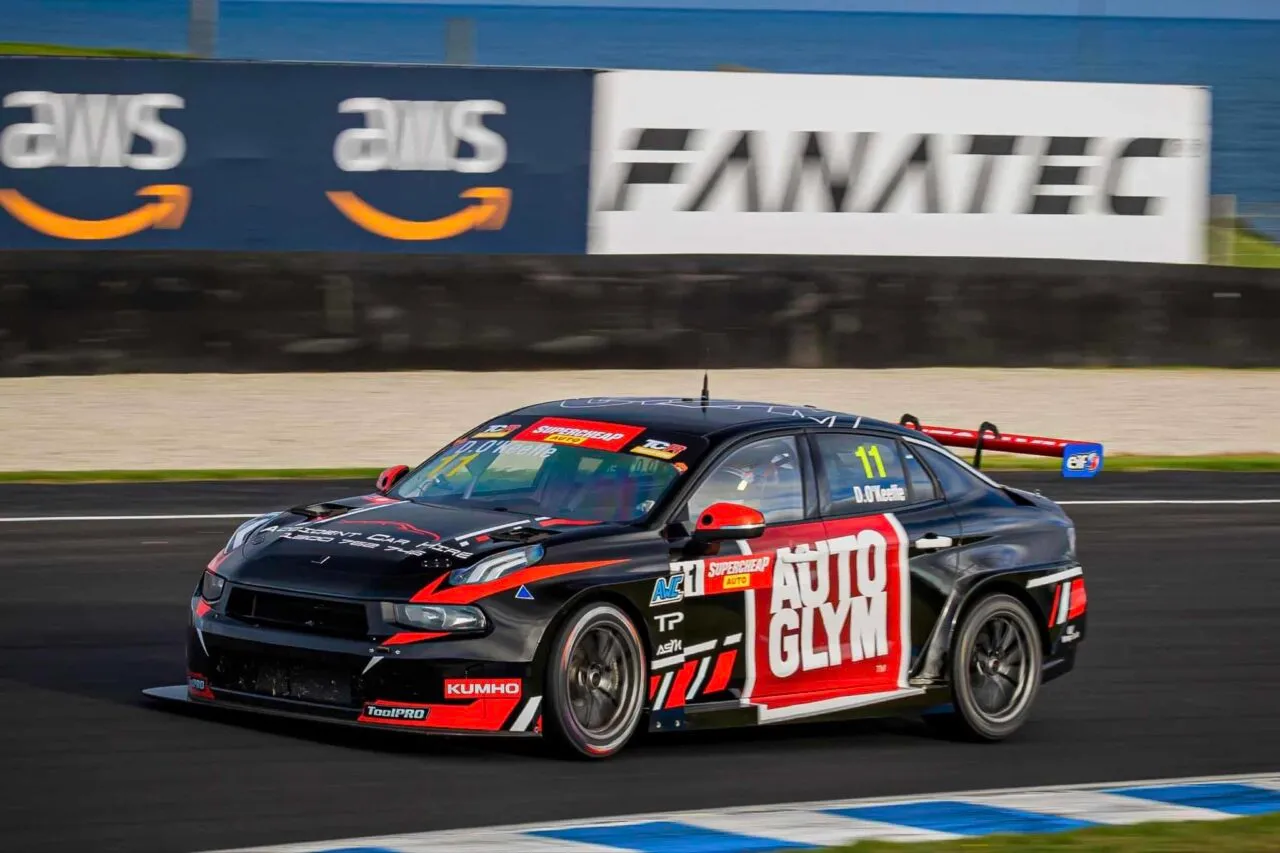 Black number 11 Autoglym Lynk & Co TCR car cornering in front of Amazon Web Services and Fanatec signs