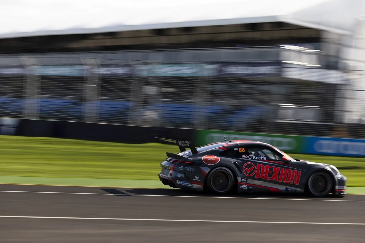 The #88 Dexion Porsche GT3 Cup car in side profile at speed in front of grandstands