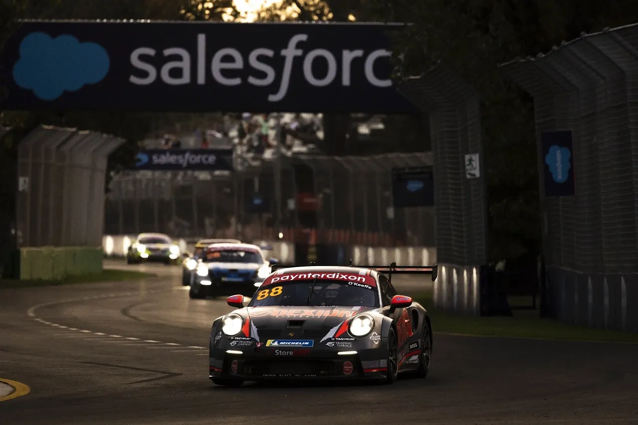 The #88 Paynter Dixon Porsche GT3 Cup car on a street circuit at dusk under Salesforce signage