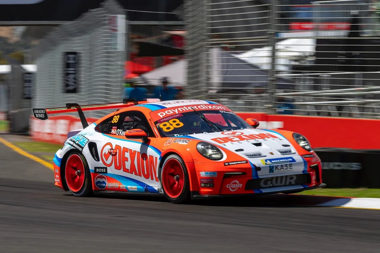 Number 88 Dexion Porsche 911 GT3 Cup car cornering beside a red wall on a street circuit