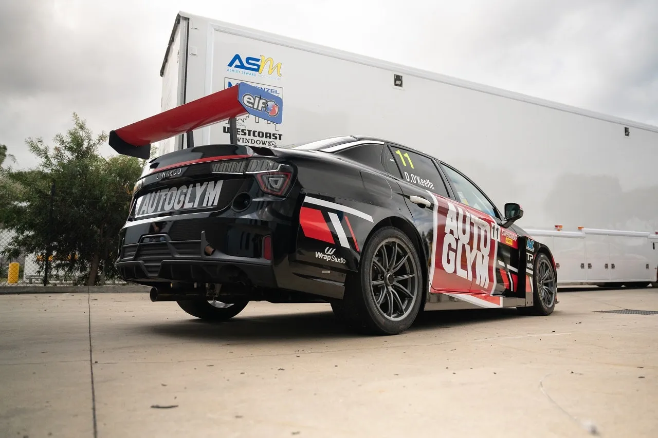 Low rear three-quarter view of the black Autoglym Lynk & Co TCR car with its red wing