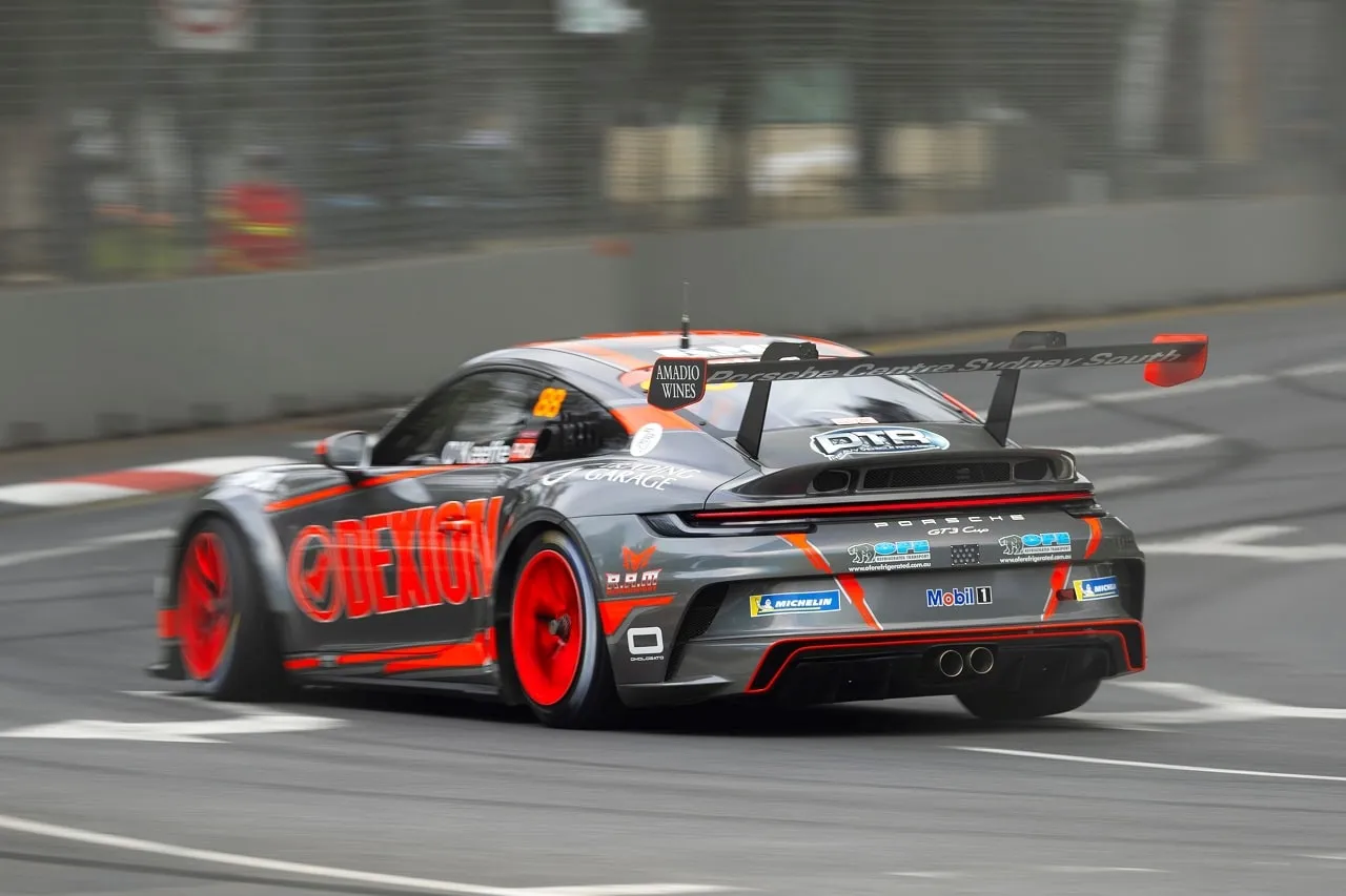 Rear three-quarter view of the grey Dexion Porsche 911 GT3 Cup car, number 88, on a wet street circuit