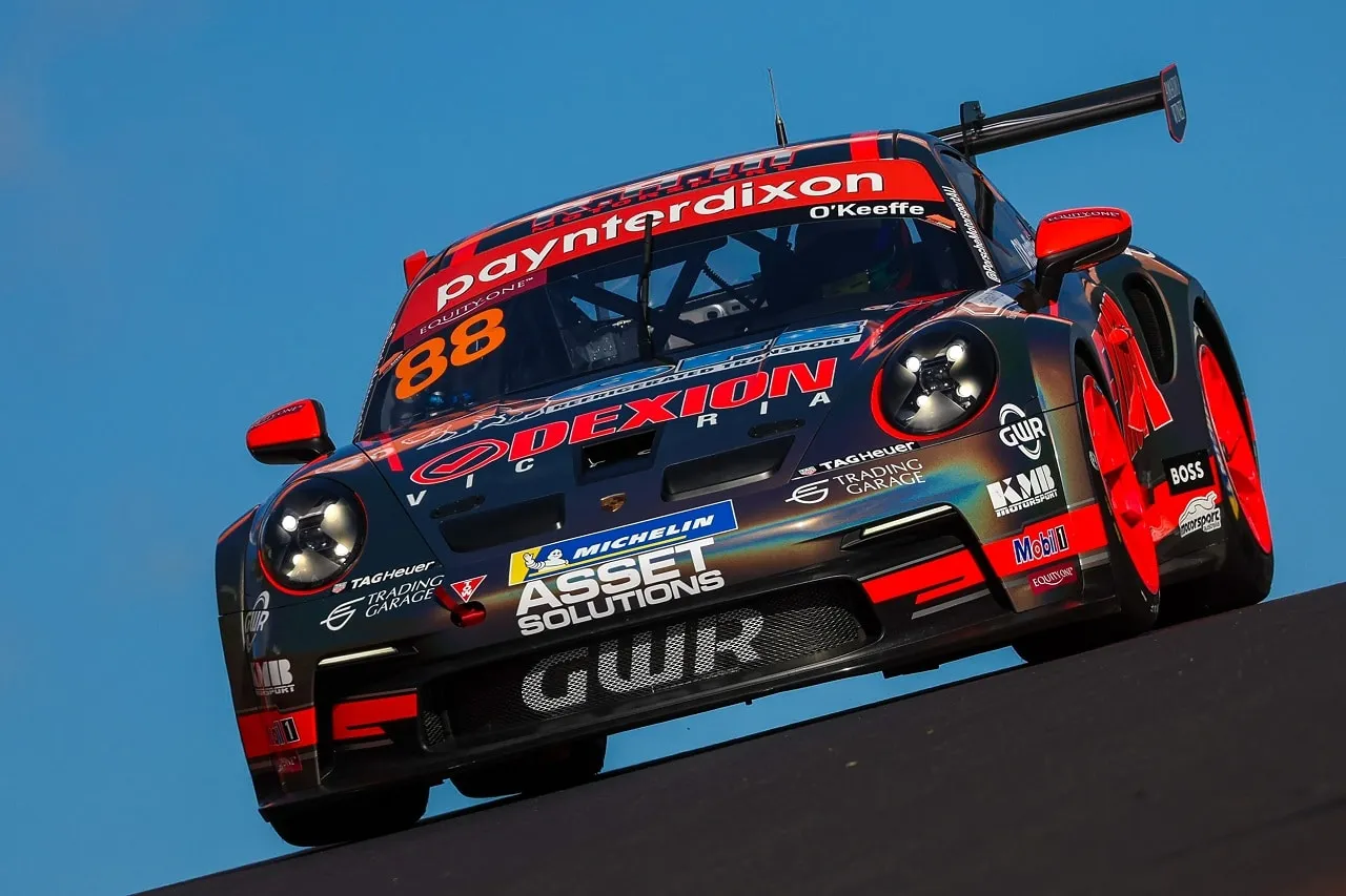 The number 88 Dexion Porsche 911 GT3 Cup car crests a rise at Bathurst under a blue sky