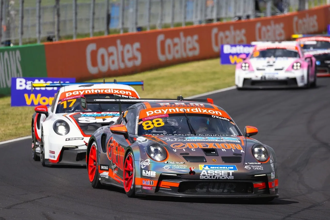 The number 88 Dexion Porsche 911 GT3 Cup car leading another Porsche past Coates signage at Bathurst
