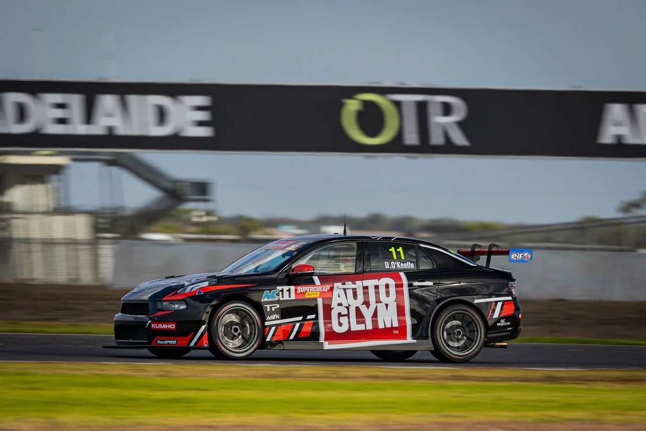 Black number 11 Autoglym Lynk & Co TCR car driven by D. O’Keeffe passing a trackside banner