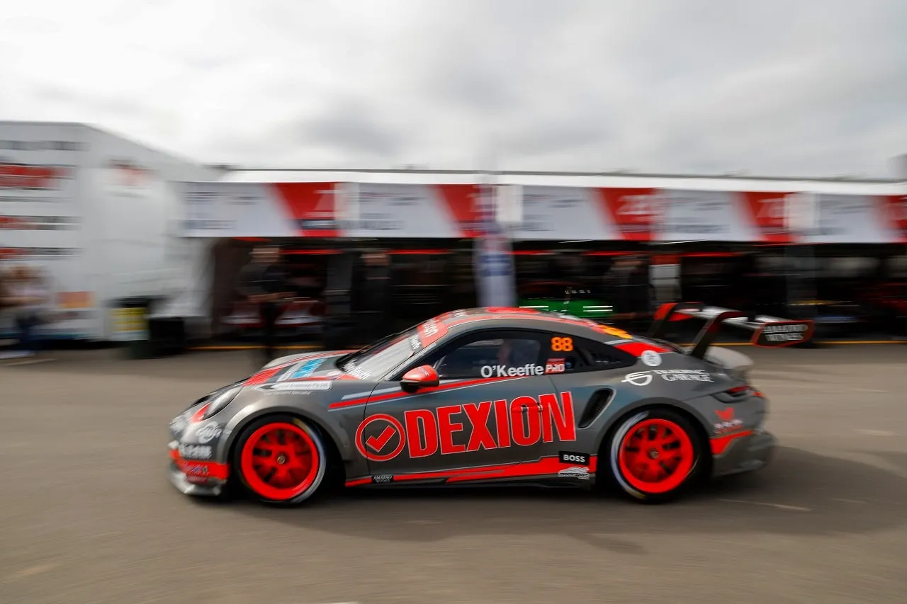 Side view of the number 88 Dexion Porsche 911 GT3 Cup car in the pit area, blurred with speed