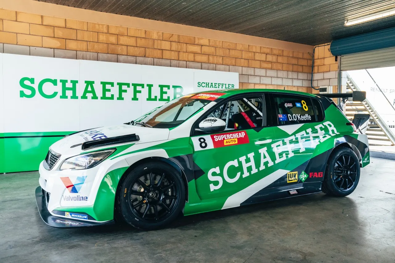 The green and white #8 Schaeffler Peugeot 308 TCR car parked in a garage