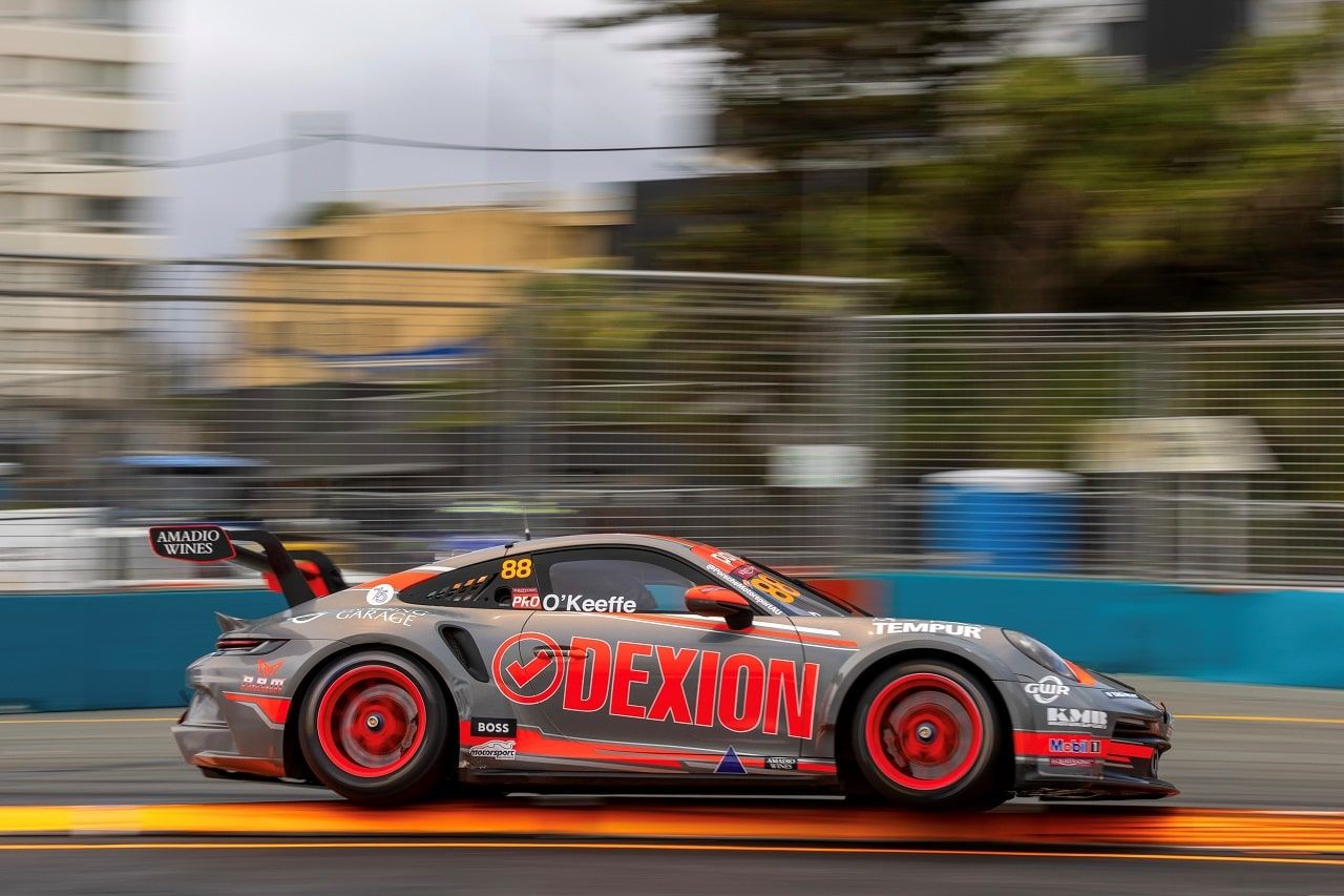 The grey Dexion Porsche 911 GT3 Cup car, number 88, speeding past a street circuit wall on the Gold Coast