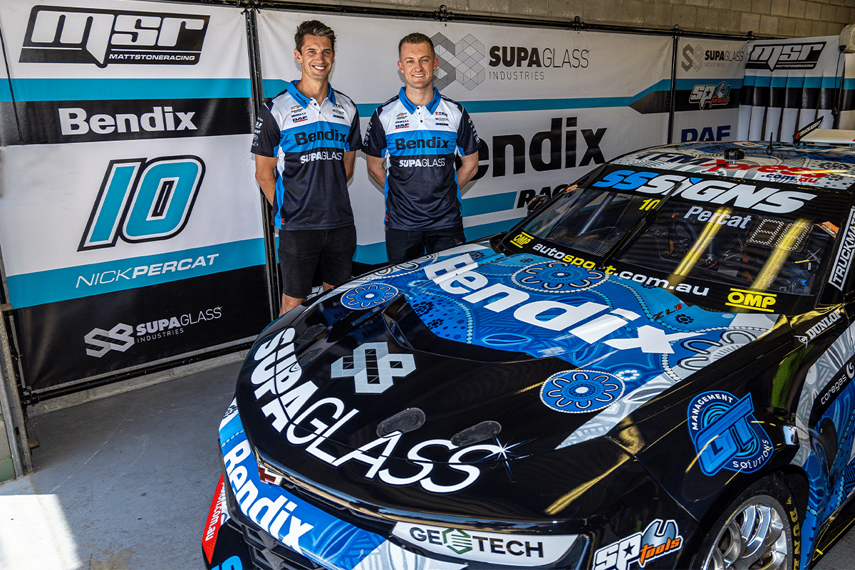 Nick Percat and Dylan O’Keeffe in Bendix team shirts standing behind the number 10 Bendix Supagas Camaro in the garage