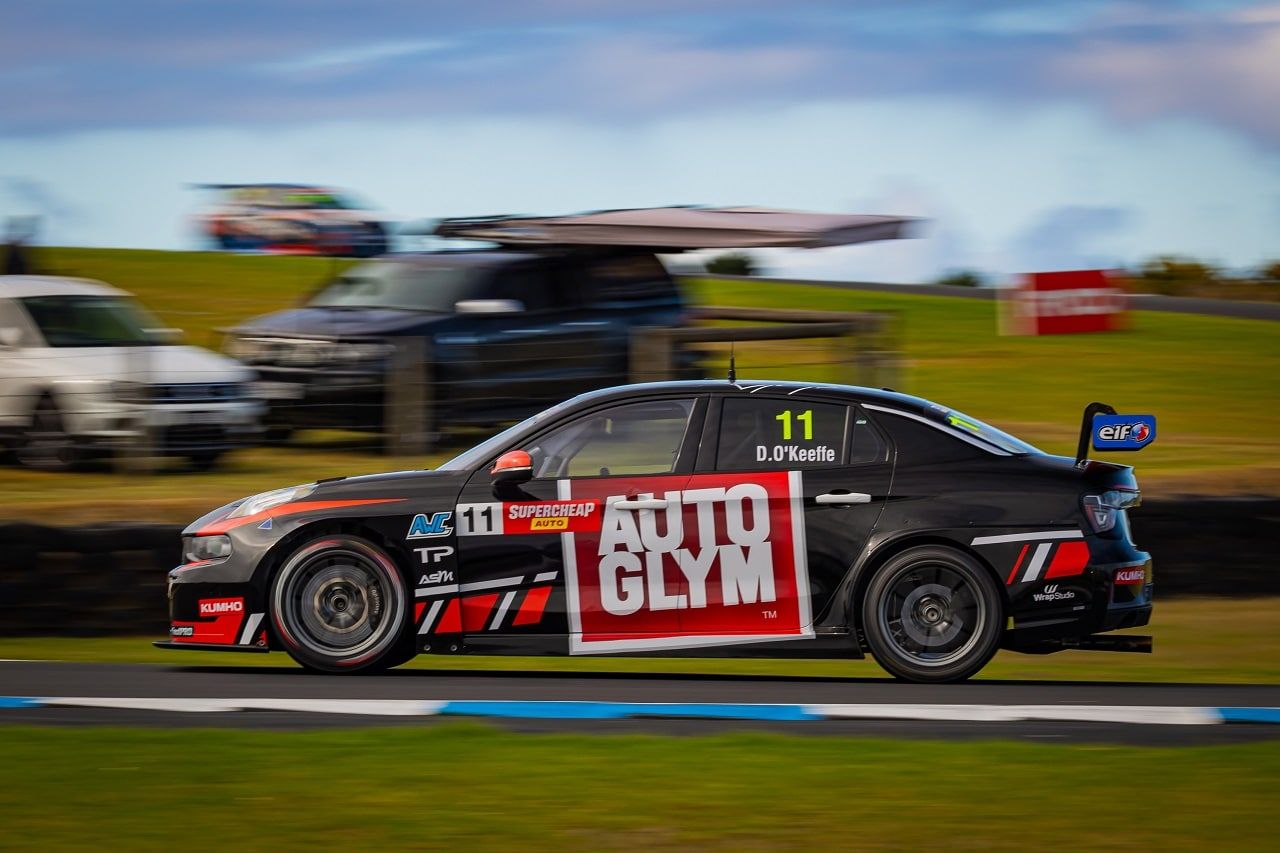 Side view of the black number 11 Autoglym Lynk & Co TCR car at speed with a blurred background