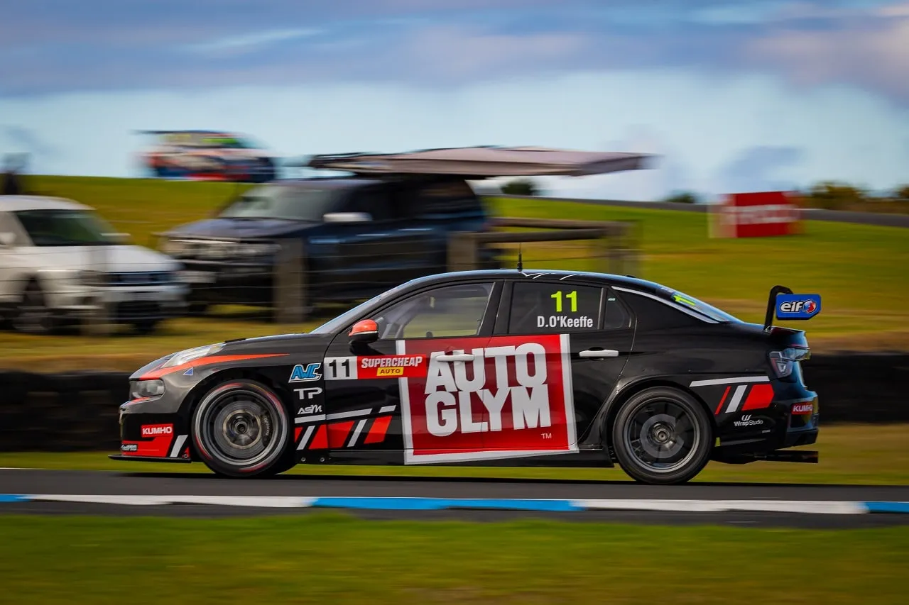 Side view of the black number 11 Autoglym Lynk & Co TCR car at speed with a blurred background